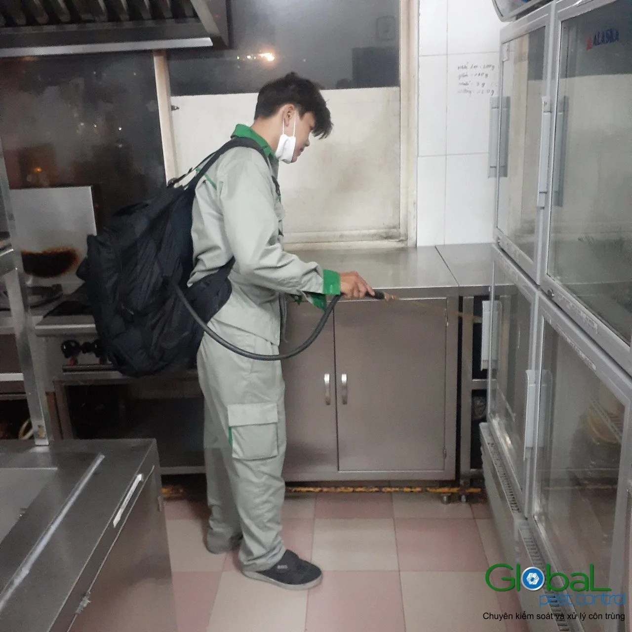 Kỹ thuật vi&ecirc;n đeo b&igrave;nh phun lưng xử l&yacute; c&ocirc;n tr&ugrave;ng trong bếp nh&agrave; h&agrave;ng