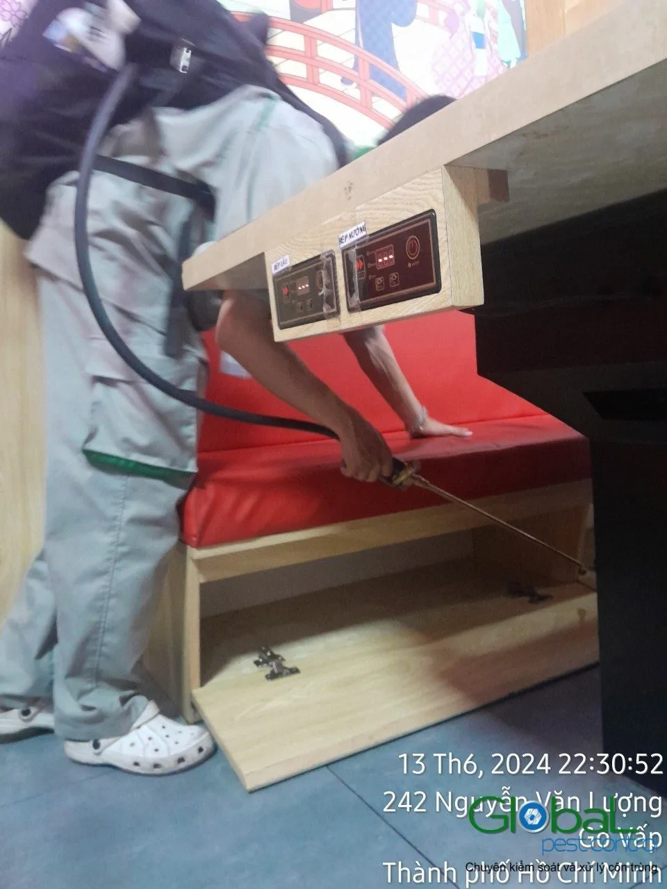 Kỹ thuật vi&ecirc;n phun thuốc diệt gi&aacute;n kẽ ghế sofa đỏ trong nh&agrave; h&agrave;ng