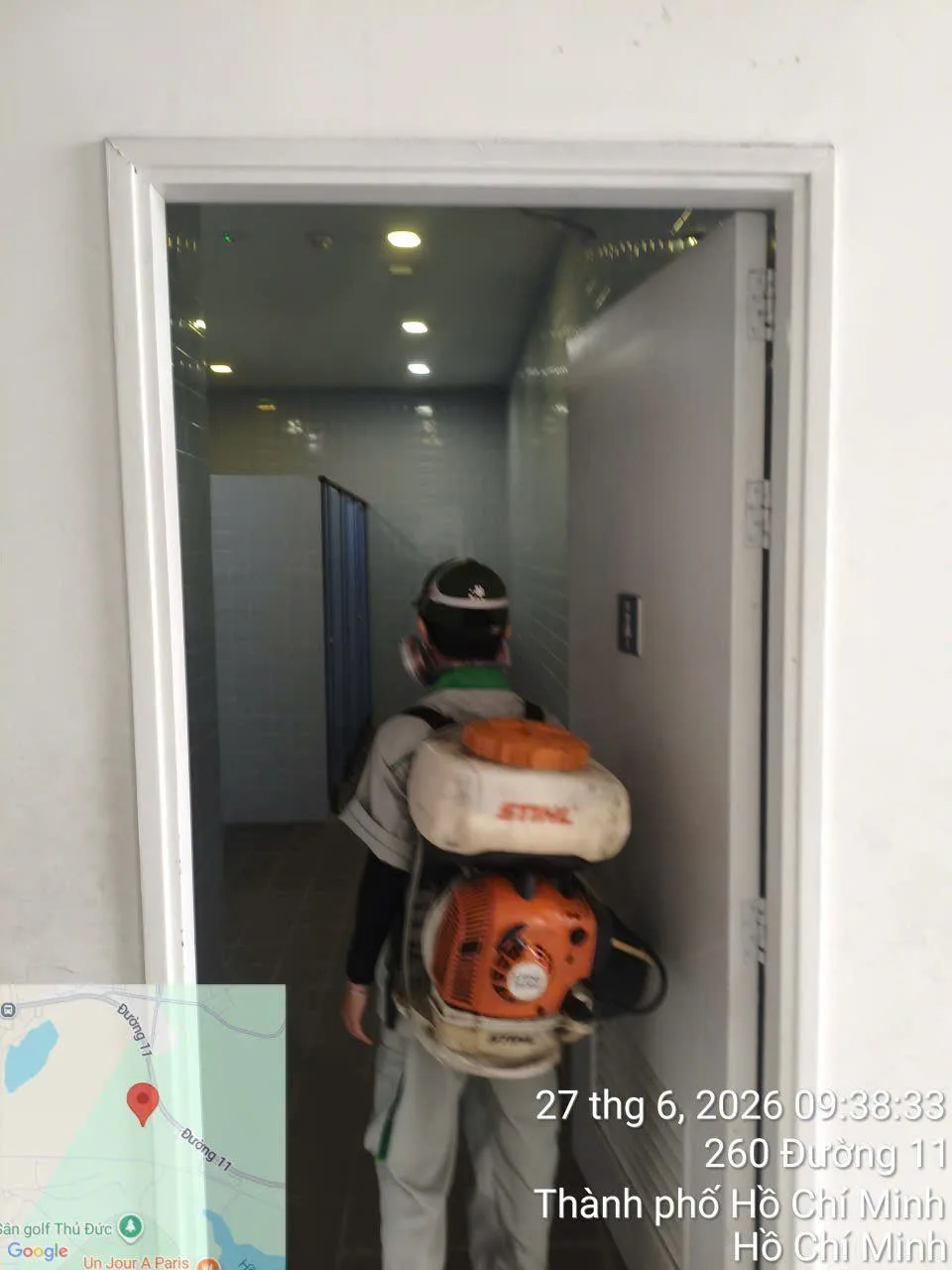 Kỹ thuật viên đeo máy phun động cơ phun thuốc nhà vệ sinh trường học