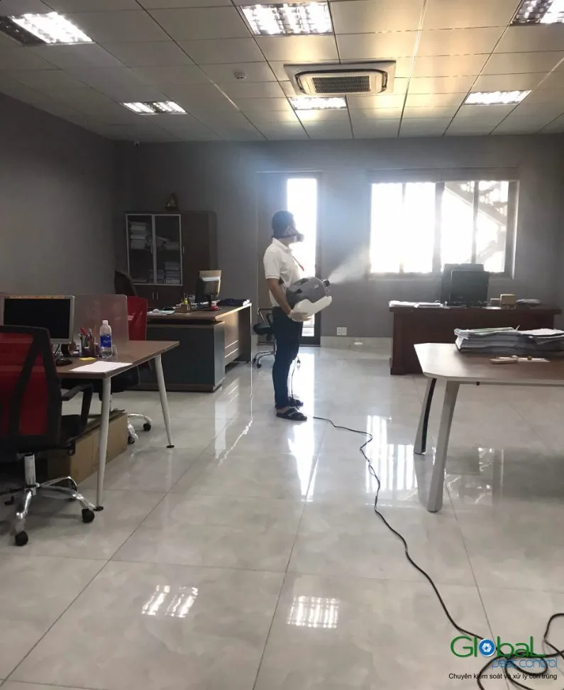 Kỹ thuật viên phun thuốc khu bàn làm việc văn phòng