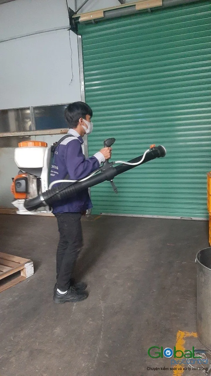 Kỹ thuật vi&ecirc;n đeo m&aacute;y phun động cơ phun thuốc khu cửa cuốn kho h&agrave;ng